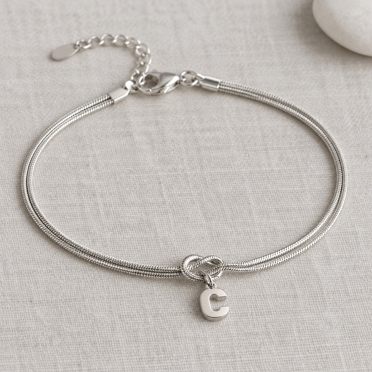 Bracelet nœud argent avec initiale C sur lin