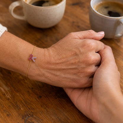 Une mère et sa fille main dans la main, le bracelet au poignet