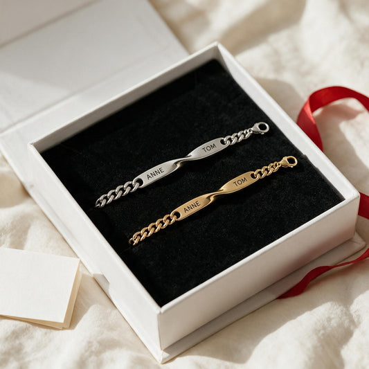 Coffret Liora ouvert sur un drap : bracelet argent et bracelet or gravés ANNE · TOM
