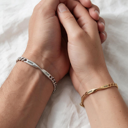 Couple main dans la main : lui bracelet argent, elle bracelet or, gravés ANNE · TOM